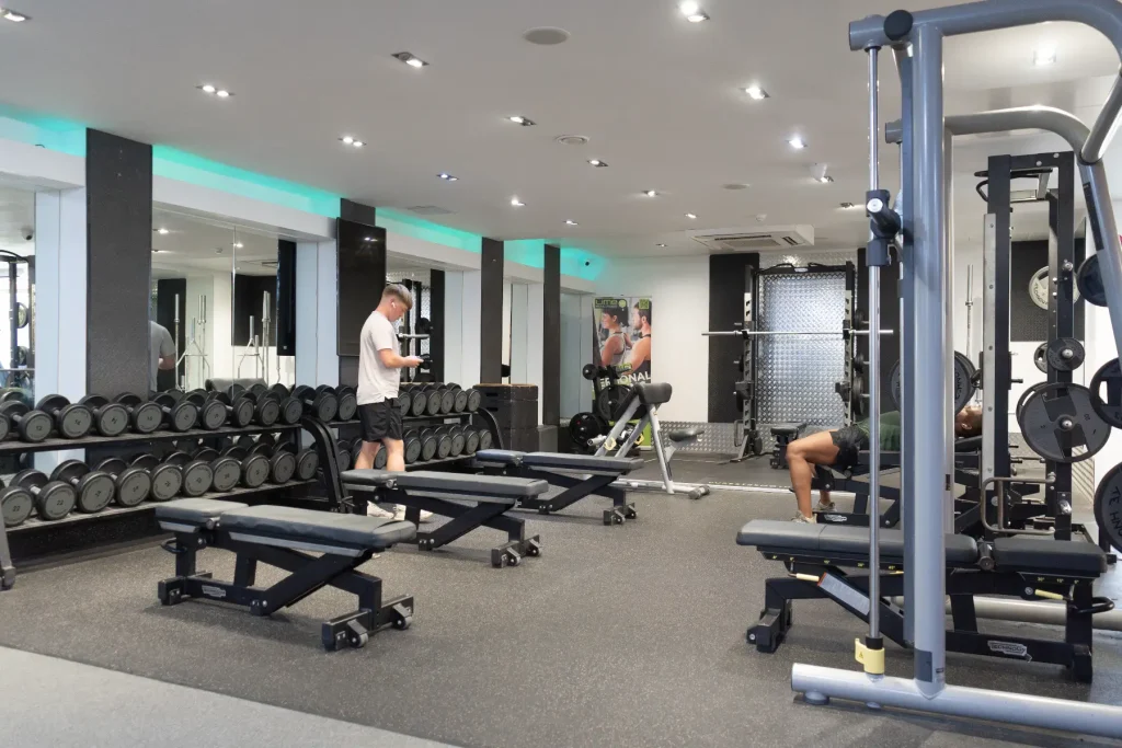 A group of young men, using the free weights section at the gym.