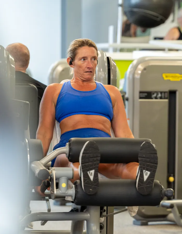 Woman using the leg extension machine at Blackshots leisure centre gym