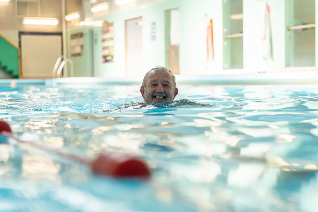 Older man smiling while swimming lengths at an Impulse Leisure swimming pool