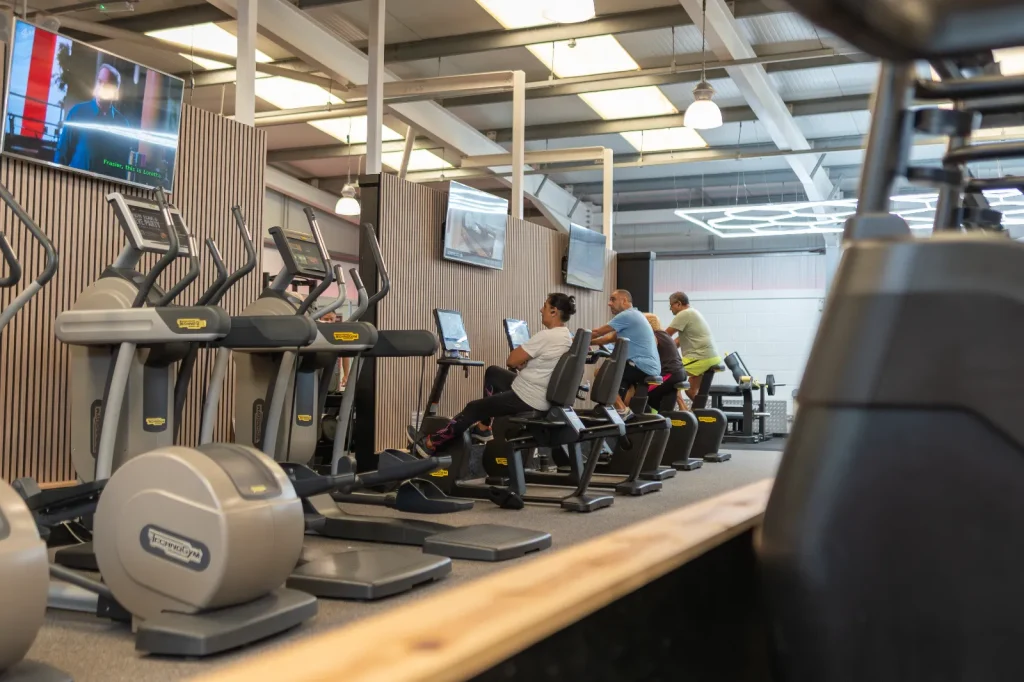 Members using Technogym cardio equipment including cross trainers and exercise bikes at Blackshots leisure centre gym