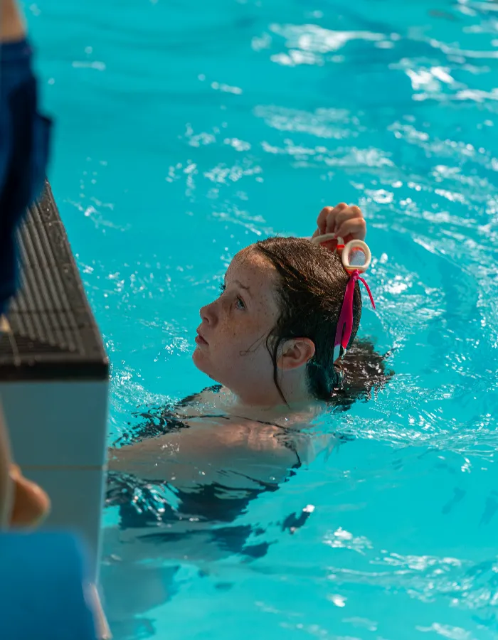 Young girl listening to her instructor during a children's swimming lesson at Impulse Leisure