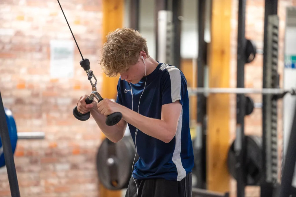 Young man performing a cable curl exercise at Corringham leisure centre gym