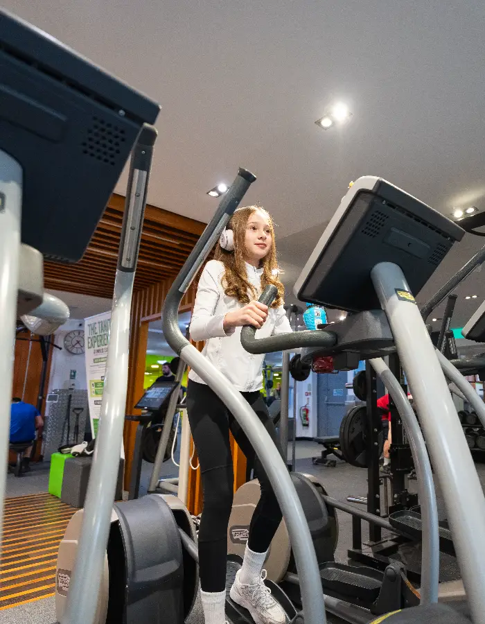 Young girl using a cross trainer machine in the gym at Belhus Park Impulse Leisure centre