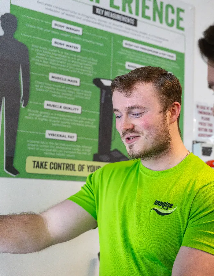 Impulse Leisure instructor guiding a junior member through a fitness assessment at Blackshots leisure centre