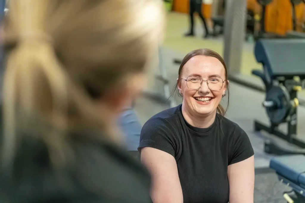 Woman smiling while talking with her female personal trainer