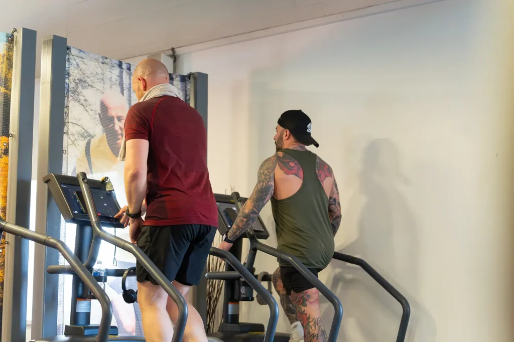 Two men working out on stairmaster machines in the gym