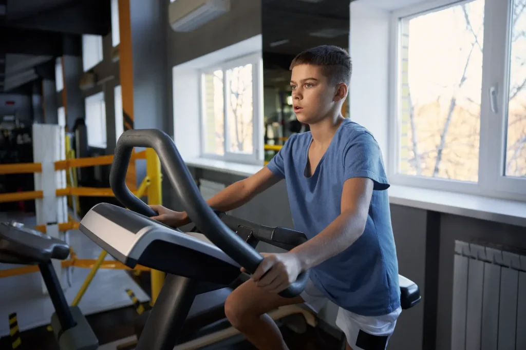 Young boy using exercise bike at Corringham leisure centre junior gym session