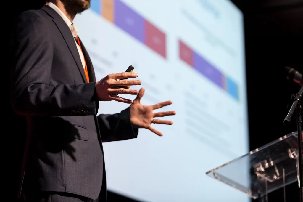 Speaker gesturing while presenting data charts at a corporate conference
