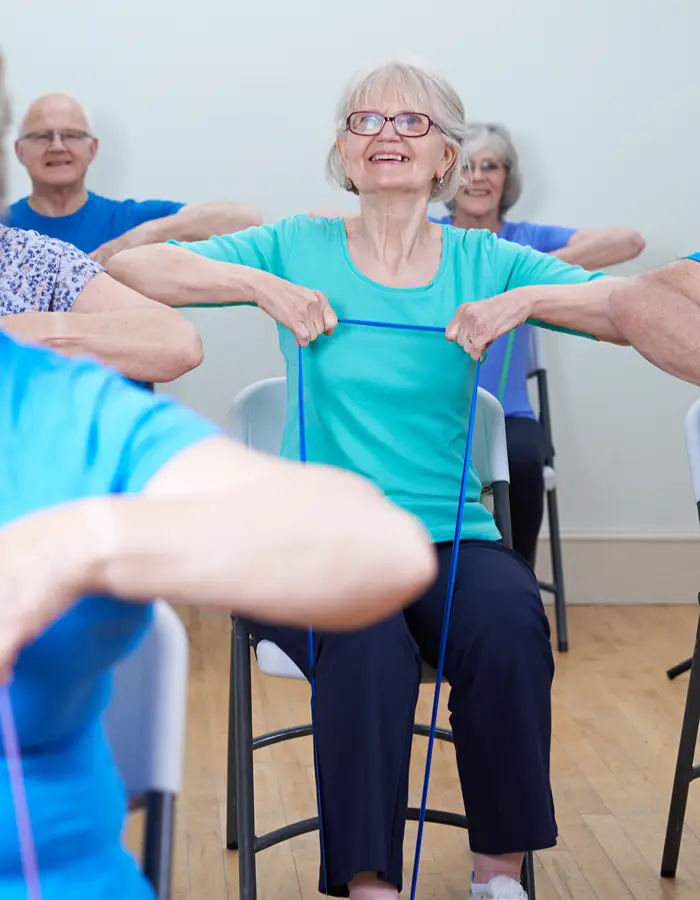 Mature lady taking part in a seated exercise class